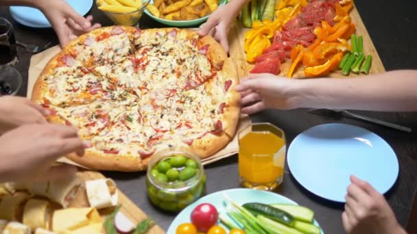 La familia come en un ambiente acogedor en casa. Comida casera, pizza casera. Familia feliz almorzando juntos sentados en la mesa abundantemente puesta — Vídeos de Stock