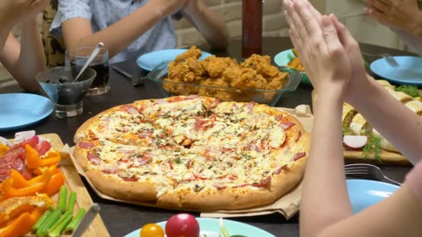 Het gezin eet in een gezellige thuisomgeving. Zelfgemaakte eten, zelfgemaakte pizza. Gelukkige familie die samen lunchen zittend aan de rijkelijk gelegde tafel — Stockvideo