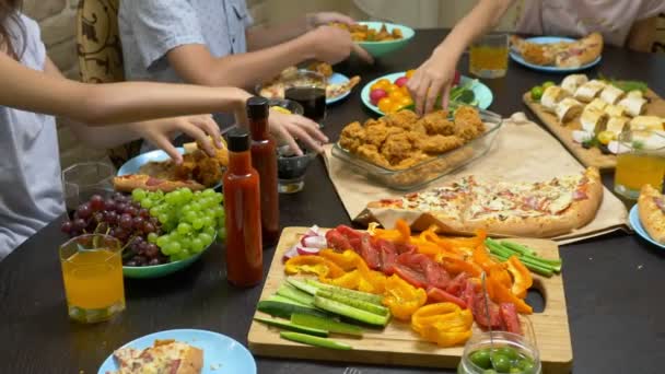 Rodzina zjada się w przytulnym domowym otoczeniu. Domowe jedzenie, domowa Pizza. Szczęśliwa rodzina o obiad razem siedzi na obficie ułożone tabeli — Wideo stockowe