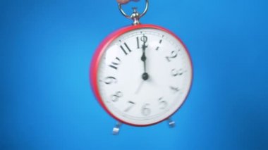 Mavi arka planda kırmızı uçan çalar saat.