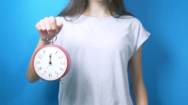 Conceito de dieta. A menina está segurando um despertador e um copo de água. tempo para beber água — Vídeo de Stock