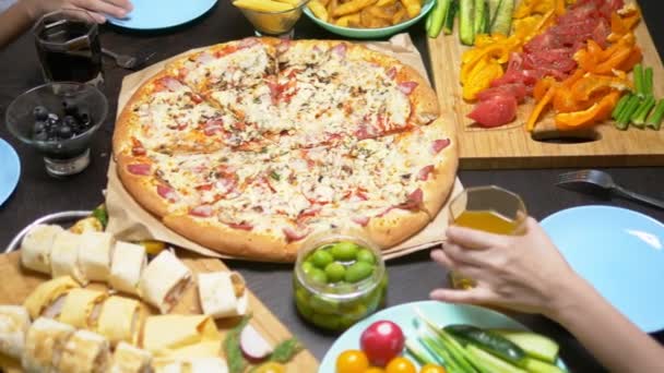 The family eats in a cozy home environment. Homemade food, homemade pizza. Happy family having lunch together sitting at the abundantly laid table — Stock Video