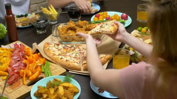 A família come em um ambiente acolhedor em casa. Comida caseira, pizza caseira. Família feliz almoçando juntos sentados na mesa abundantemente colocada — Vídeo de Stock