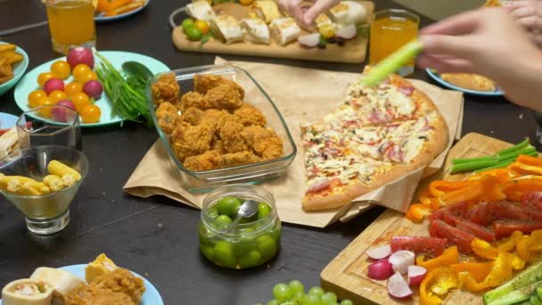 La familia come en un ambiente acogedor en casa. Comida casera, pizza casera. Familia feliz almorzando juntos sentados en la mesa abundantemente puesta — Vídeos de Stock