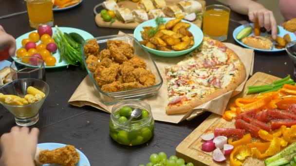 La familia come en un ambiente acogedor en casa. Comida casera, pizza casera. Familia feliz almorzando juntos sentados en la mesa abundantemente puesta — Vídeos de Stock