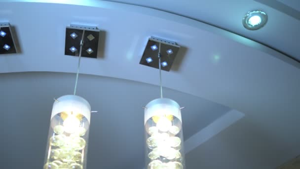 Lujosa lámpara de araña de cristal moderna en un techo de varios niveles — Vídeos de Stock