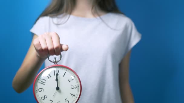 Concepto de dieta. La chica sostiene un despertador y un vaso de agua. tiempo para beber agua — Vídeo de stock