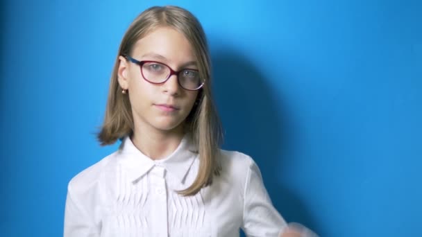 El concepto del tiempo es estudiar, volver a la escuela. colegiala con gafas sostiene gran reloj y muestra el pulgar hacia abajo — Vídeos de Stock