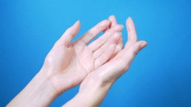 Doğal manikür ile nazik kadın elleri mavi bir arka planda güzel hareket. Metin için Yerleştir.