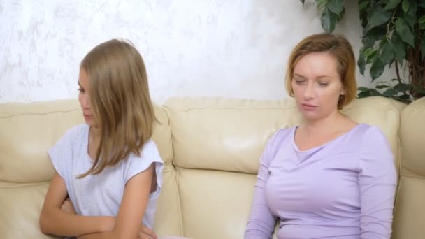 Disappointed mother reprimands her daughter, who ignores her, sitting on the sofa in the living room — Stock Video