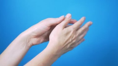 Doğal manikür ile nazik kadın elleri mavi bir arka planda güzel hareket. Metin için Yerleştir.