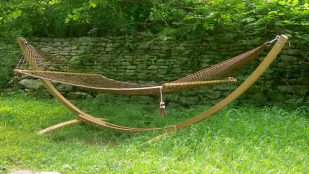 Hamaca colgante para relajarse en el césped en el jardín de verano, sin cuerpo — Vídeo de stock