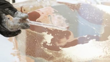 Akışkan sanat akrilik boyama süreci. Yakın çekimde, birisi pipetten taze akrilik boyaların üzerine alkol düşürür. akrilik boyalar ve alkol damlaetkileşim süreci