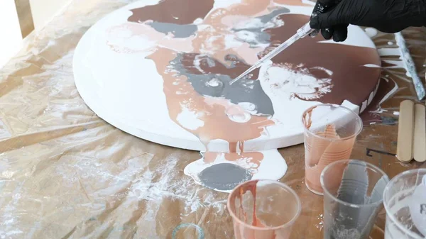 Processo di pittura acrilica arte fluida. Primo piano, qualcuno fa cadere l'alcol da una pipetta su vernici acriliche fresche. il processo di interazione di vernici acriliche e gocce di alcool — Foto Stock