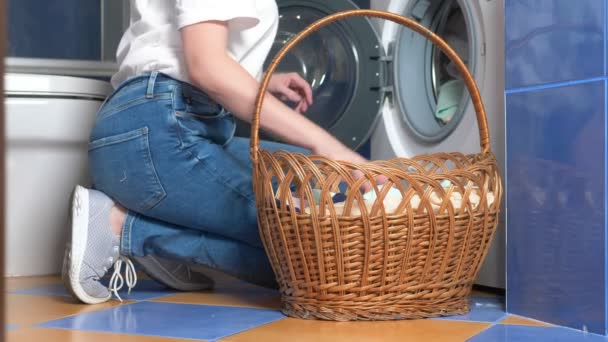 Close-up. mulher irreconhecível colocando pano na máquina de lavar roupa da cesta de lavanderia — Vídeo de Stock