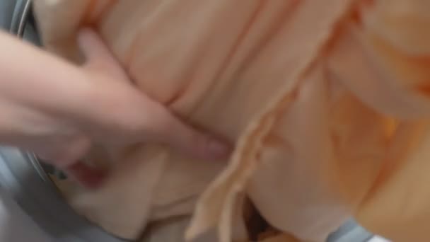 Γκρο πλαν. γυναίκα παίρνει μπουγάδα από το στεγνωτήριο — Αρχείο Βίντεο