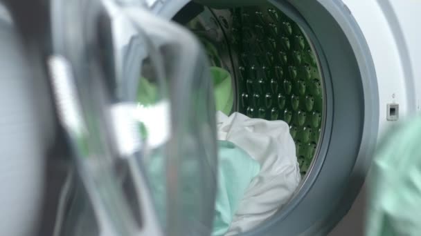 Close-up. female hands put fabric in a washing machine — Stock Video