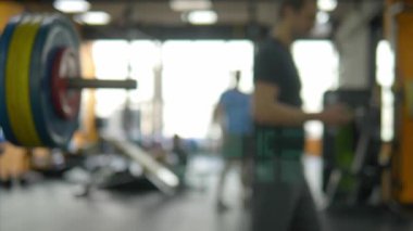 Arka planı bulanıklaştırın. spor salonunda barbells. Ağırlık eğitim barı ile bulanık fitness salonu
