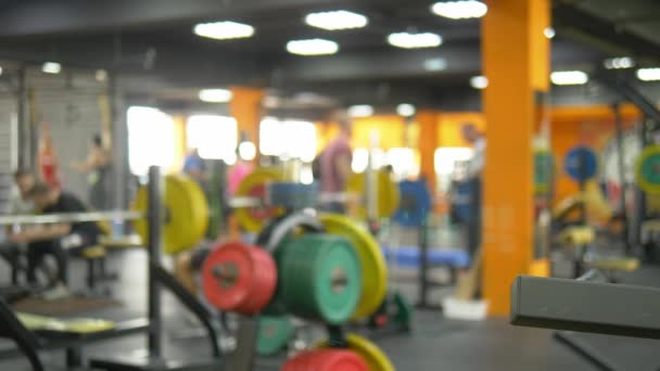 Fondo borroso. campanas en el gimnasio. Sala de fitness borrosa con barra de pesas — Vídeos de Stock