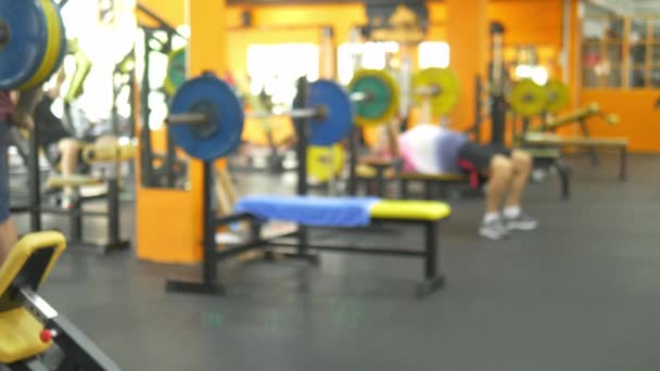 Hintergrund verschwimmen lassen. Hanteln in der Turnhalle. verschwommener Fitnessraum mit Hantelstange — Stockvideo