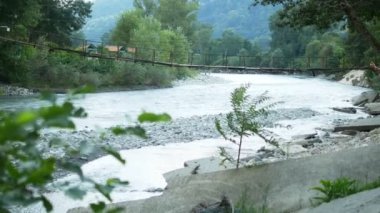 macera seyahat konsepti. Bir dağ nehri üzerinde asma köprü. kopyalama alanı