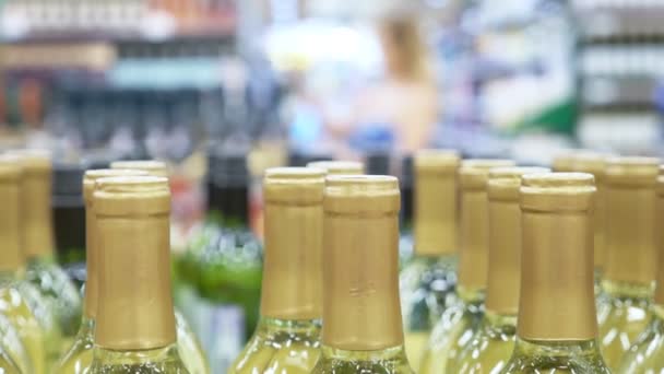 V lahvích s alkoholem v ostrosti. Rozostřit pozadí oddělení alkoholu v supermarketu. — Stock video