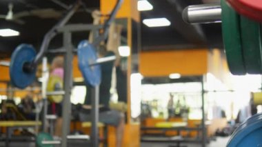 Arka planı bulanıklaştırın. spor salonunda barbells. Ağırlık eğitim barı ile bulanık fitness salonu