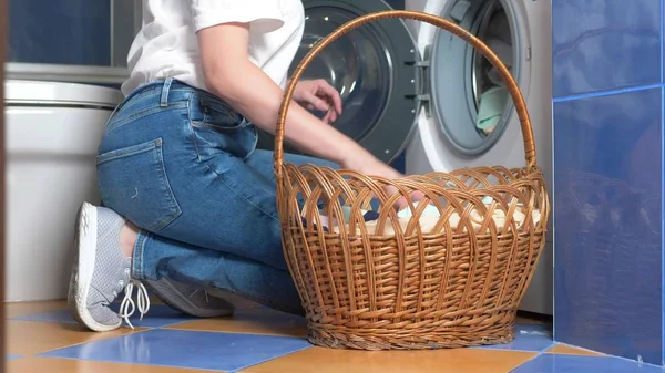 Primer plano. mujer irreconocible poner tela en la lavadora de la cesta de la ropa — Foto de Stock