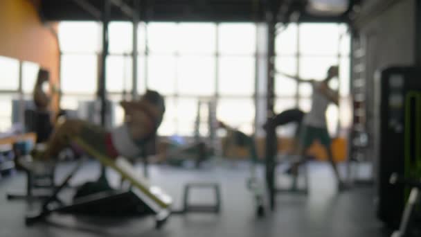 Suddig bakgrund. människor som deltar i idrott i gymmet för fitness, inredning av ny modern utrustning, sport Concept — Stockvideo