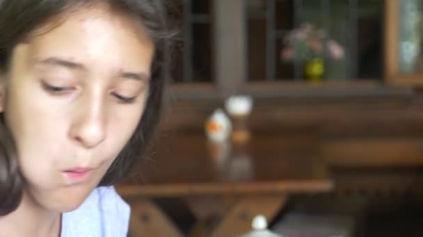 Girl eats baguette with jam and drinks tea. close-up — Stock Video