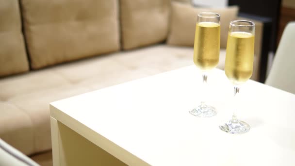 Dois copos de champanhe em um quarto de fundo borrado no interior de um hotel de luxo . — Vídeo de Stock