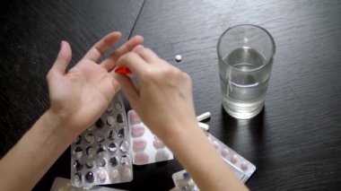 yukarıdan görüntüleyin. Haplara dokunan ellerin yakın. Sağlık kavramı, vitamin eksikliği. kadın sıralar hapları masada oturan