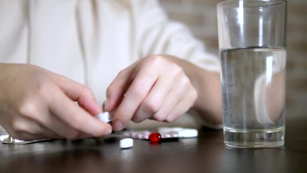 Primer plano de las manos tocando pastillas. El concepto de cuidado de la salud, deficiencia de vitaminas. mujer ordena píldoras sentadas a la mesa — Vídeos de Stock