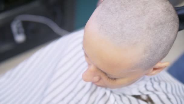 Kuaför elektrikli jiletle bir kadının kafasındaki saçı tıraş ediyor. Yakından kapatın. profesyonel bir saç makinesi ile saç kesme — Stok video