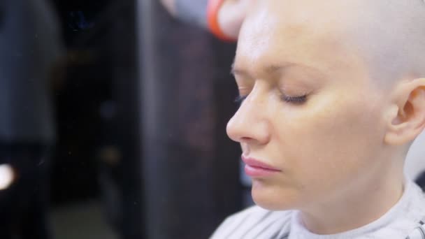 美容師は、電気かみそりで女性の頭の上の髪を剃ります。クローズアップ。プロのヘアマシンでヘアカット — ストック動画