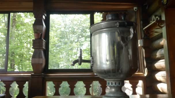 Smoke from the cover of a traditional Russian samovar on the veranda of a wooden house in the forest — Stock Video