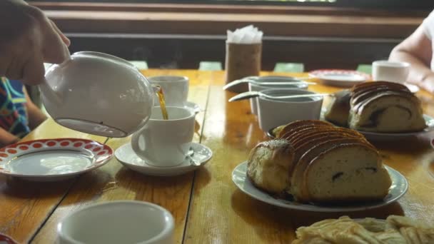 Thé traditionnel russe. une table servie avec des tasses à thé, théières, sur les rouleaux de table avec des crêpes de graines de pavot, confiture et miel — Video