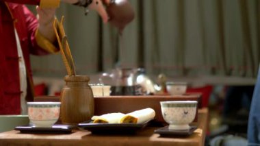 Keskinlik Çin çay bardağı, geleneksel Çin çay içme sürecinin bulanık bir arka plan üzerinde. usta bardak içine çay döker