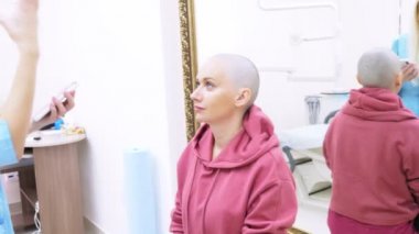 bir klinikte bir doktor ile istişare kel kadın. Trikooloji, onkoloji, alopesi kavramı.