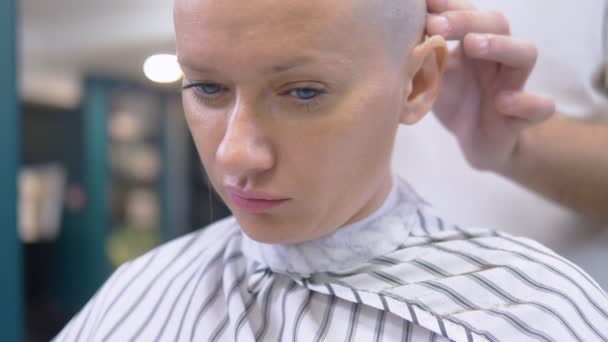 Kuaför elektrikli jiletle bir kadının kafasındaki saçı tıraş ediyor. Yakından kapatın. profesyonel bir saç makinesi ile saç kesme — Stok video