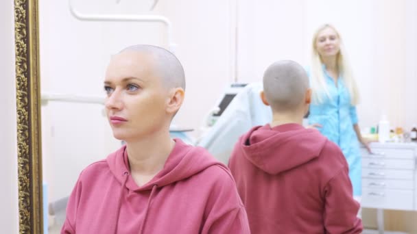 Skallig kvinna vid ett samråd med en läkare på en klinik. Begreppet Trichology, onkologi, alopeci. — Stockvideo
