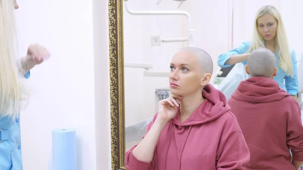 Mujer calva en una consulta con un médico en una clínica. El concepto de tricología, oncología, alopecia . — Foto de Stock