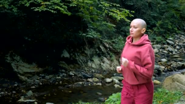 Glatzköpfige junge Frau joggt im Herbst Park oder Wald. Konzept eines gesunden Lebensstils. — Stockvideo