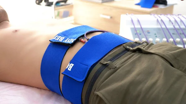 Primer plano. procedimiento de estimulación eléctrica para los músculos abdominales. un hombre estimula pasivamente los músculos abdominales . — Foto de Stock