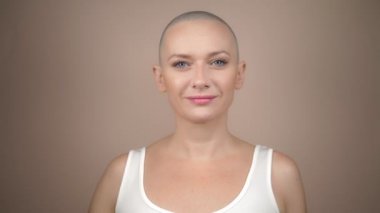 Güzel kel kadın elinde pembe bir kurdele tutuyor. nazik pastel arkaplan.