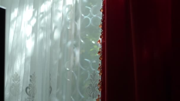 Hermosas cortinas rojas y blancas en la ventana en un día claro y soleado. resplandor soleado en las cuentas de la decoración . — Vídeos de Stock