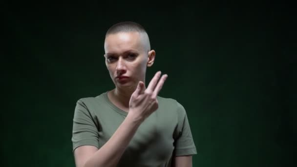 Estilo militar. brutal chica calva se aplica maquillaje de guerra camuflaje en la cara. espacio de copia — Vídeos de Stock