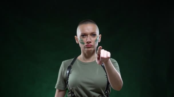 Il ritratto di una donna militare calva arrabbiata, con una mano gestuale in cui tiene un machete, ti taglia la testa. espressione di emozioni e concetti di stile di vita. Fondo nero . — Video Stock