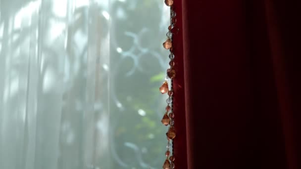 Beautiful red and white curtains on the window on a clear sunny day. sunny glare on the beads of the decor. — Stock Video