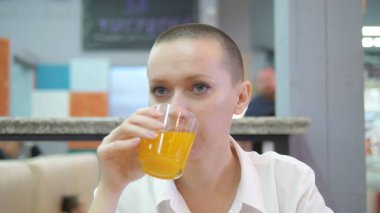 Çekici kel kadın bir restoranda öğle veya akşam yemeği yiyor.